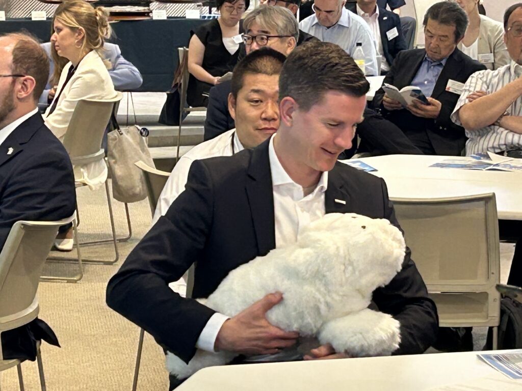 参加者に抱かれるアザラシ型ロボット「パロ」